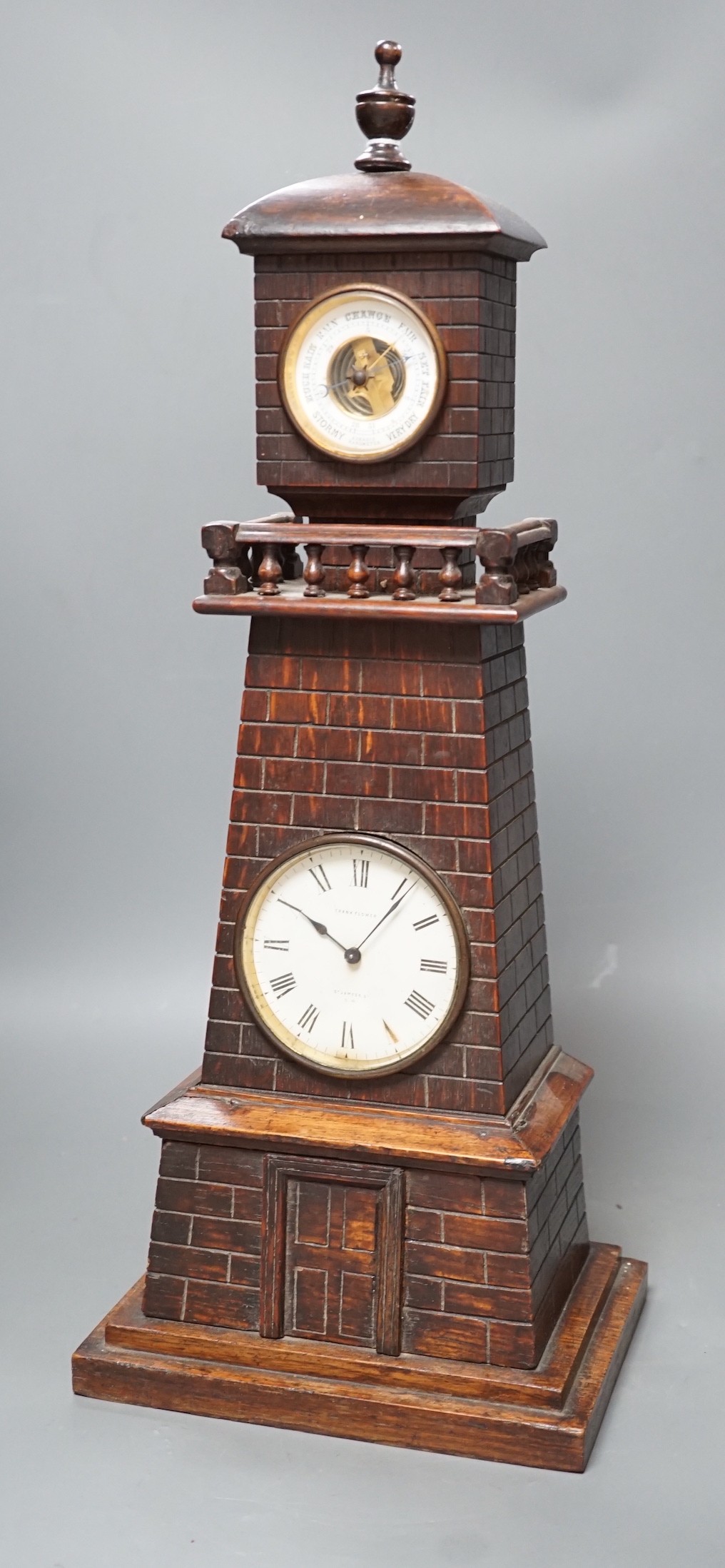 A late Victorian carved oak 'lighthouse' combined mantel timepiece and barometer, signed Frank Flower, St James' St, S.W, Height 53 cm